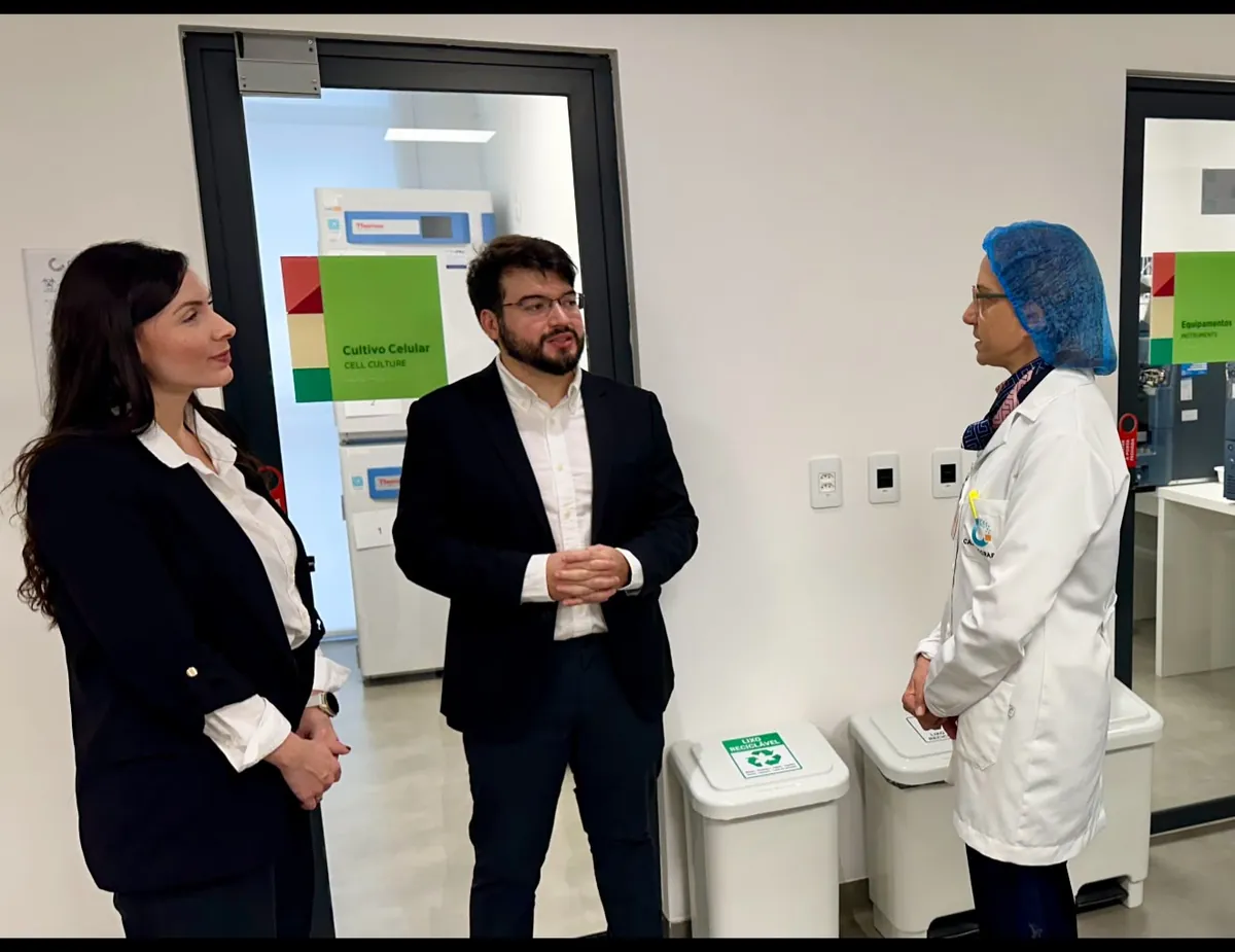 Visitantes conversam com uma profissional da Casa dos Raros no corredor dos laboratórios de cultivo celular e de equipamentos